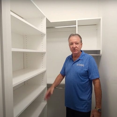Custom walk-in closet design by Gulfshore Closets, featuring built-in shelving, drawers, and hanging space for optimal organization.